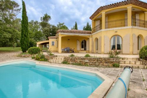 une maison avec une piscine devant dans l'établissement Les Girolles - Villa climatisée avec piscine, à Brignoles