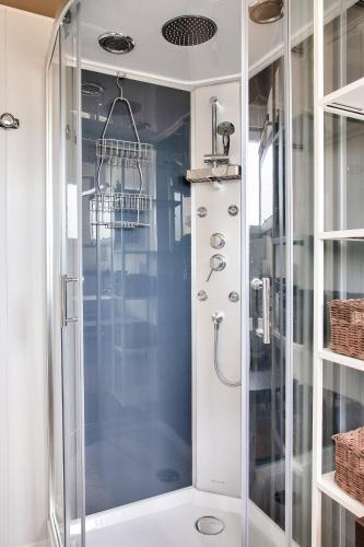 une douche avec une porte vitrée dans une salle de bain dans l'établissement Grands espaces à Plovan - 6 Personnes, à Plovan