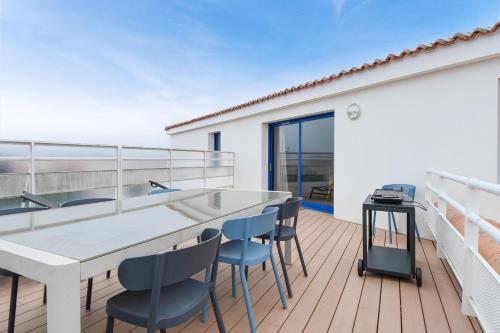 d'un balcon avec une grande table blanche et des chaises. dans l'établissement Appart pour 6 adultes et 2 enfants avec terrasse, à Noirmoutier-en-l'lle