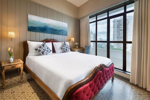 a bedroom with a large bed and a large window at Arnna Hotel- Goregaon East in Mumbai