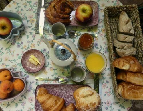 a table topped with plates of bread and pastries at Chambre d'hôtes in Lançon-Provence