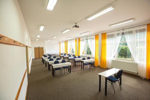 a classroom with rows of desks and chairs and windows at Pension v parku Český Šternberk in Český Šternberk
