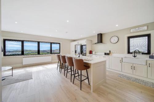 una cocina con una gran isla con taburetes de bar en Seaview Lodge Apartment 'Sleeping 4 Guests', en Tieveborne