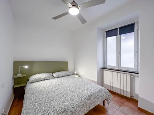 een slaapkamer met een bed en een plafondventilator bij Bilocale fronte Porto Antico in Savona