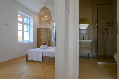 a bedroom with a bed and a bathroom with a sink at Katina's Coastal Oasis in Pylos