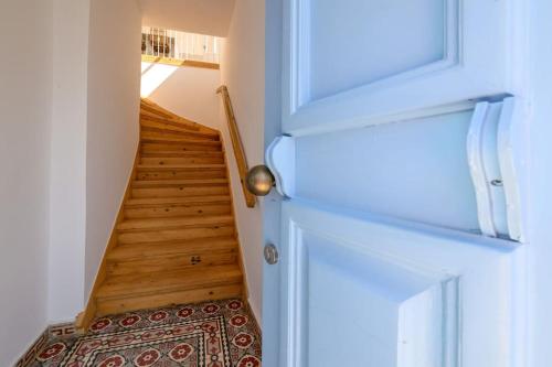 a hallway with a staircase with wooden floors and a door at Katina's Coastal Oasis in Pylos