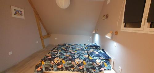 een kleine slaapkamer met een bed met een kleurrijk dekbed bij Maison en Périgord in Plazac