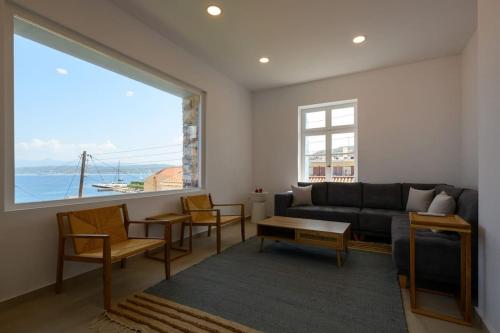 a living room with a couch and a large window at Katina's Coastal Oasis in Pylos
