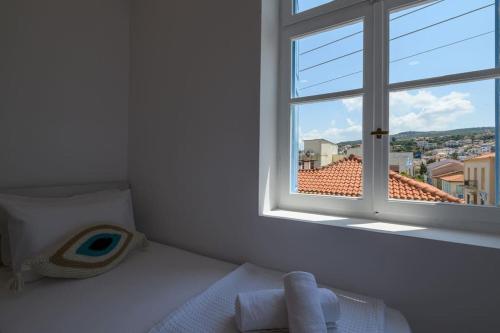a bedroom with a window with a view of a city at Katina's Coastal Oasis in Pylos
