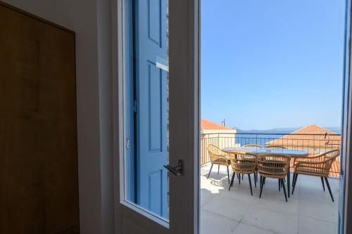 a door leading to a balcony with a table and chairs at Katina's Coastal Oasis in Pylos