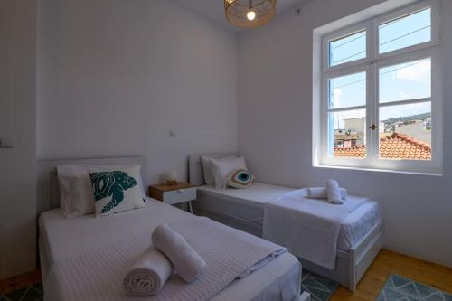 a bedroom with two beds and a window at Katina's Coastal Oasis in Pylos