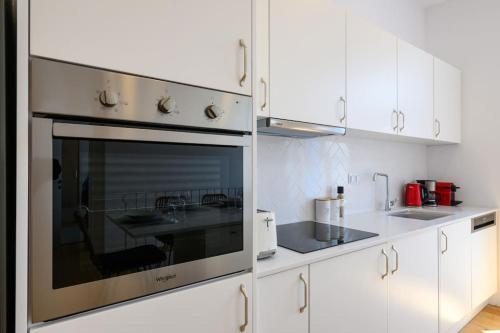 a kitchen with white cabinets and an oven at Katina's Coastal Oasis in Pylos
