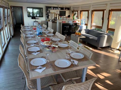 a long wooden table with chairs and plates on it at Hotel Plutitor Egreta1 in Sfântu Gheorghe