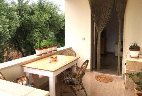 porche con mesa y sillas en el patio en CASE VACANZE 'RICCIO E SALVIA' A S. M. DI LEUCA, en Marina di Leuca