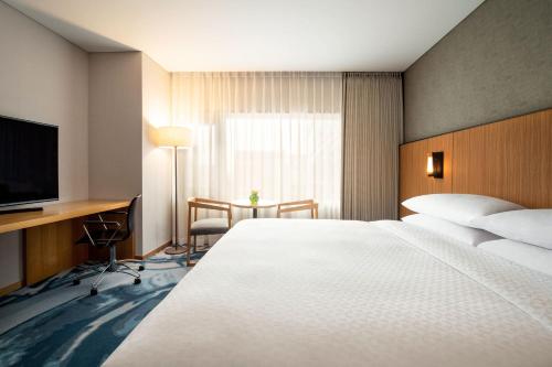 a hotel room with a bed and a desk and a television at Four Points by Sheraton Seoul, Guro in Seoul