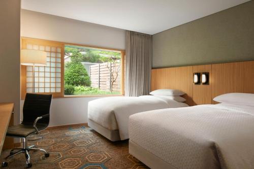 a hotel room with two beds and a window at Four Points by Sheraton Seoul, Guro in Seoul