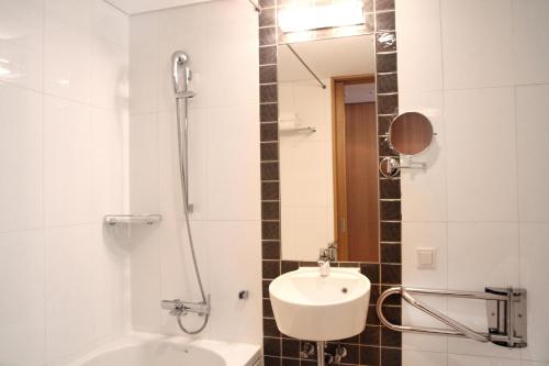 a white bathroom with a sink and a shower at Four Points by Sheraton Seoul, Guro in Seoul