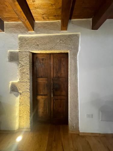 una gran puerta de madera en una habitación con suelo de madera en L'araucaria Le Camere, en Riola Sardo