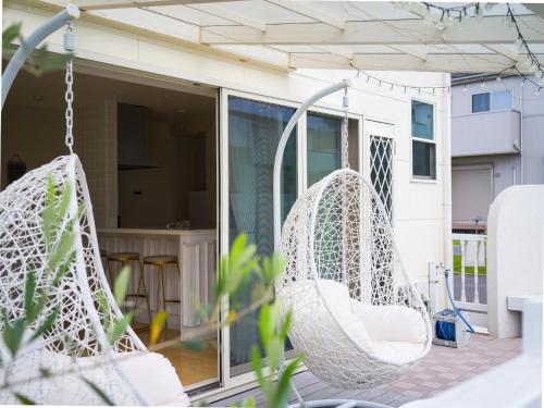 - deux hamacs suspendus en blanc sur une terrasse couverte dans l'établissement Villa OLIVE Sajima -佐島の丘- ペット可, à Yokosuka