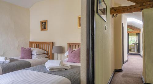 a bedroom with two beds with purple and white pillows at Hullet Hall in Lake Side