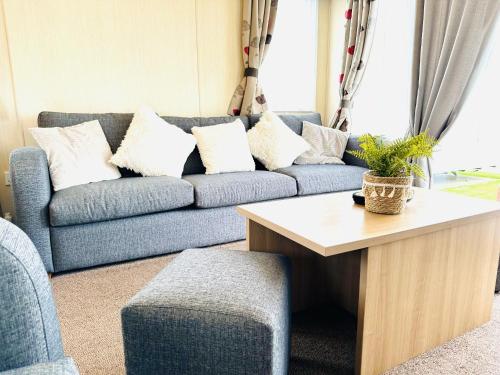 a living room with a blue couch with white pillows at Cosy Corner in Filey