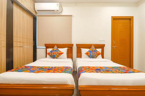 two beds sitting next to each other in a room at FabExpress RS Living in Hyderabad