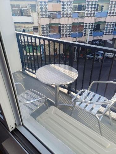 a balcony with a table and chairs on a balcony at "Hibiscus" city center room in Papeete