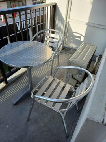 a table and a table and a chair on a balcony at "Hibiscus" city center room in Papeete