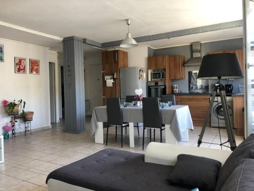 a living room and kitchen with a table and chairs at Appartement balcon, place de parking, centre ville in Valence