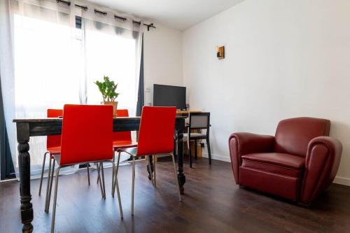 une salle à manger avec une table et des chaises rouges dans l'établissement T2 Tout Confort avec terrasse- Métro Saint Cyprien, à Toulouse