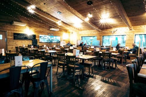 a restaurant with tables and chairs and people sitting at them at Woodlakes Park By Liv Retreats in Kings Lynn