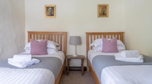 a bedroom with two beds with pink and white pillows at Hullet Hall in Lake Side