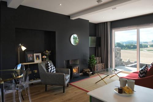 a living room with black walls and a fireplace at Luxury Lodge with Hot Tub at Lindores in Newburgh