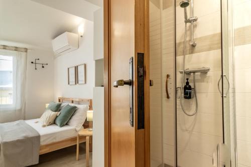 a small bathroom with a shower and a bed at WanderJohn penthouse 5terreparco in Riomaggiore