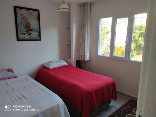 a bedroom with a red bed and a window at Denizli Öğretmenler Sitesi in Didim