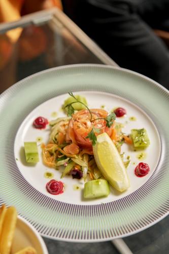 a plate of food with shrimp and vegetables on a table at Herbert Park Hotel and Park Residence in Dublin