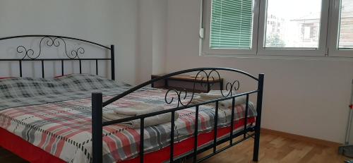 - une chambre avec un lit avec un cadre métallique et une fenêtre dans l'établissement Apartment Martin, à Gevgelija