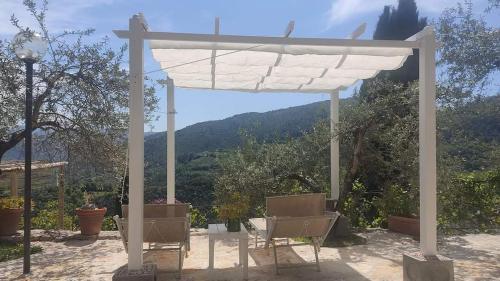 a white pergola with two chairs under it at Guesthouse Runcini in Ferentillo