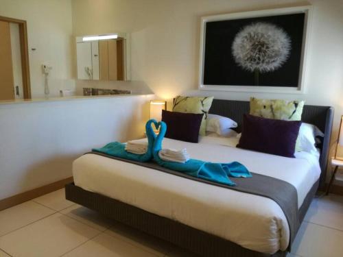 sypialnia z dużym łóżkiem z niebieskimi ręcznikami w obiekcie Latitude Sea Front Luxury Apartment w mieście Black River