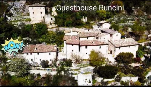 un gruppo di edifici bianchi seduti su una collina di Guesthouse Runcini a Ferentillo