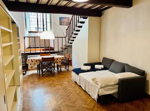 1 dormitorio con cama, mesa y escalera en Ponte Vecchio cozy Oltrarno apartment, en Florencia