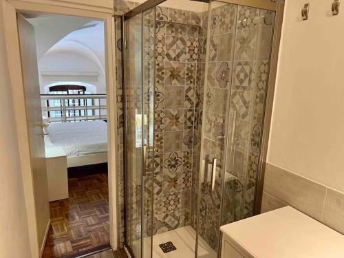 y baño con ducha y puerta de cristal. en Ponte Vecchio cozy Oltrarno apartment, en Florencia
