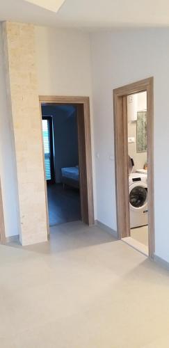 een kamer met 2 open deuren en een wasruimte bij Apartments Boljat in Trogir