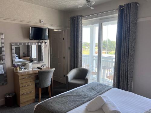 斯凱格內斯的住宿－薩沃伊酒店，酒店客房设有一张床、一张书桌和一个阳台。