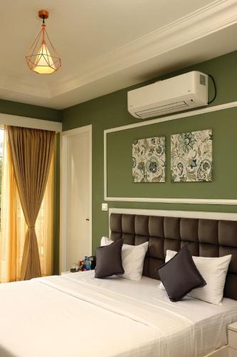 a bedroom with a bed with a air conditioner on the wall at White Mint in Yercaud