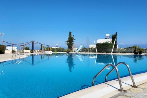a large swimming pool with blue water at 2 bedroom ground floor apartment in Bahçeli