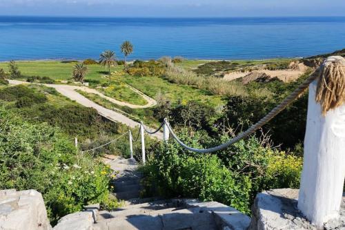 a path leading down a hill to the ocean at 2 bedroom ground floor apartment in Bahçeli