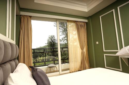 a bedroom with a bed and a window with a balcony at White Mint in Yercaud