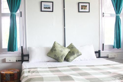 a bedroom with a bed with two pillows on it at Forest Side Farm - Homestay at Kotabagh Near Nainital and Jim Corbett in Kota Bāgh