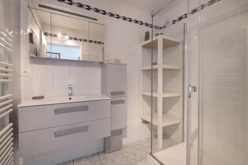 une salle de bain blanche avec un lavabo et une douche dans l'établissement Appartement pour 4 - 300m du centre-ville, au Pouliguen